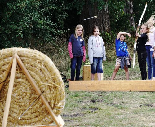 Spaß beim Bogenschießen und Stelzenlaufen